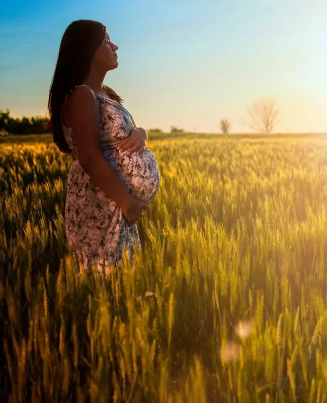 A pregnant woman gently holding her belly, radiating calm and warmt